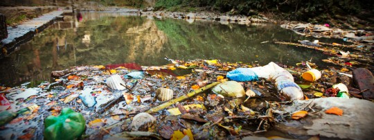 Garbage and Plastic Bottle In Polluted River