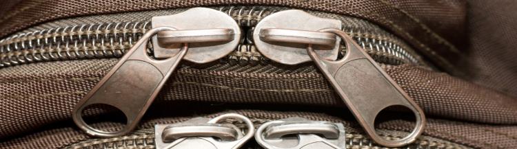 Closeup view of closed zippers on a bag.