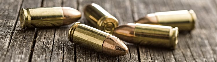 9mm pistol bullets on old wooden table.