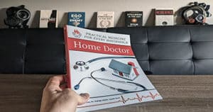 Holding the Home Doctor Book With Prepping Background (c)