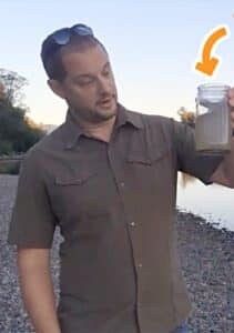 Does The LifeStraw Expire - holding up a glass of murky water